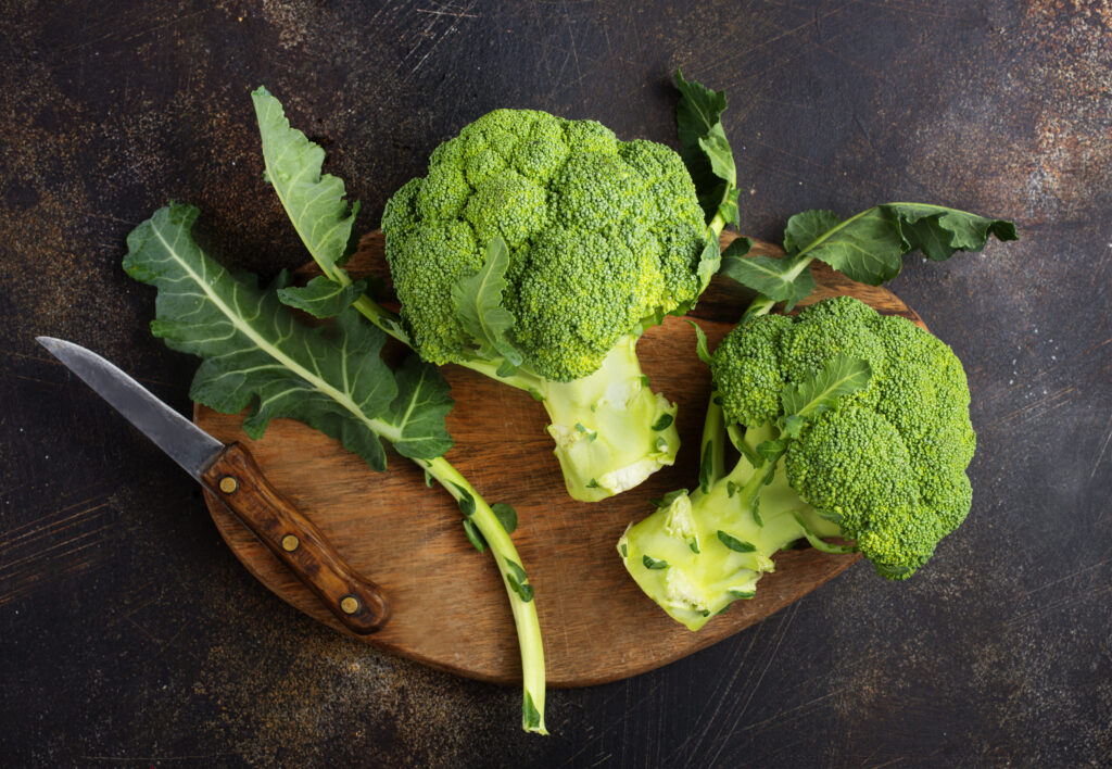Le broccoli, un indispensable de l'alimentation du perroquet Amazone Deux broccolis sur une table avec un couteau